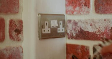 Ev mutfağındaki elektrik prizine prizler yerleştiriyorum.