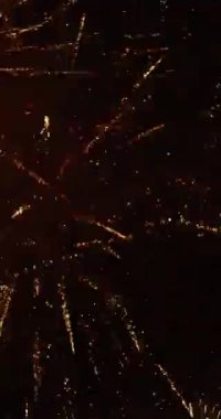 Havai fişek gösterisi havai fişeklerin altın tonunda patlaması 124; 4K VERTICAL VIDEO