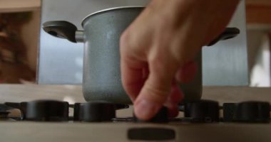 Ev mutfağındaki bir tencerenin altındaki gaz ocağında ateş yakmak... 124K video.