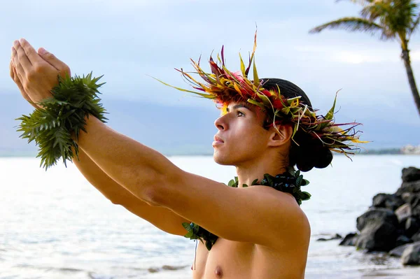 Male Hula Dance performs on the beach with expressive hand movements.