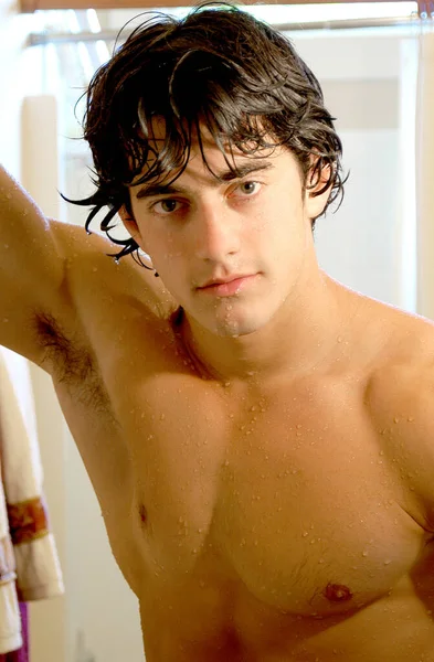 一个英俊的年轻人站在那里 湿淋淋地站在淋浴间里找一幅性感的肖像 — 图库照片