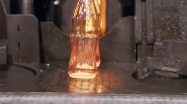 Cam şişe üretimi. Bir üretim tesisinde kırmızı sıcak cam şişeler