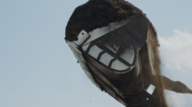 İndüksiyon gübre üretim alanı. Gübre yığınlarını ve traktörleri gösteren makineler gübre yüklüyor