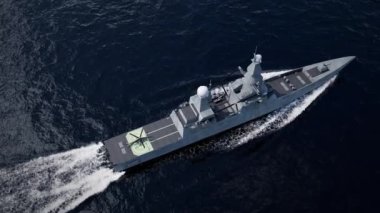 Büyük bir savaş gemisi, üzerinde helikopterle denizde seyrediyor.