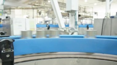 Konserve gıda üretim tesisinde hızlı bir taşıyıcı banttaki domates sosu kutuları.