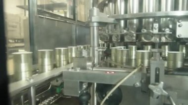 Konserve gıda üretim tesisinde hızlı bir taşıyıcı banttaki domates sosu kutuları.