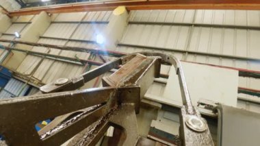 Sanayi robotu üretim sırasında metal parçaları kaldırıyor