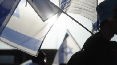Ulusal İsrail bayrakları sallayan göstericiler