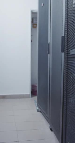 点滅するライトが付いているデータ センターの大きいコンピュータ サーバー部屋の縦のビデオ — ストック動画
