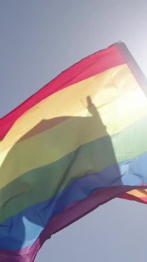 Gurur yürüyüşü sırasında gökkuşağı bayrağının yavaşça dalgalanması.