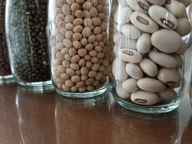 Kurutulmuş çiğ mısır ve Sorghum tohumlu cam kavanoz.