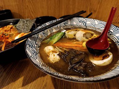 Asya usulü erişte çorbası, kasede et ve yumurta.