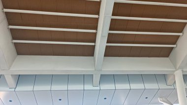 Bir binanın tavanı kahverengi tahtalarla kaplıdır. Tahtalar bir düzen oluşturacak şekilde düzenlenmiş.