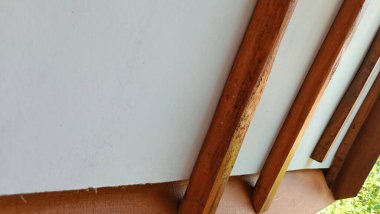 Tahta kirişler kahverengi ve beyaz duvar sade. Görüntünün basit ve minimalist bir havası var.