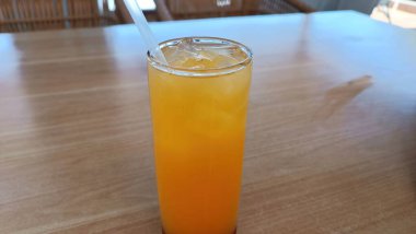 İçinde pipet olan bir bardak portakal suyu.