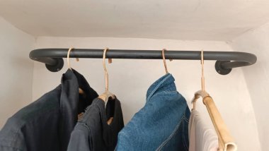 Siyah ve mavi bir gömlek elbise askısında asılı.