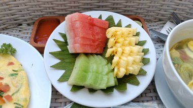 Havuz kenarındaki yüzen tepside renkli tropikal meyve tabağı