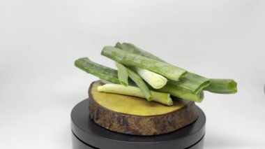 Taze yeşil soğanlar ahşap mutfak sunumu için sergileniyor..