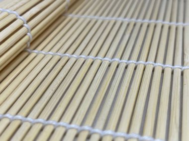 Bir bambu paspasın yakın çekimi, dokuma dokusunu ve doğal malzemelerini sergiliyor..