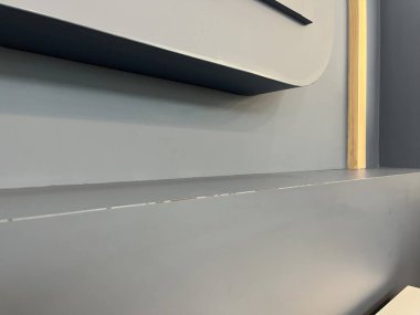 Modern bir iç duvarın yakın plan ve zarif bir rafı var.