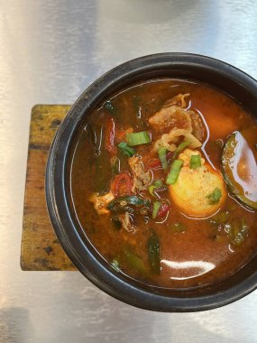 Sebze ve yumurtalı baharatlı bir kase çorba.