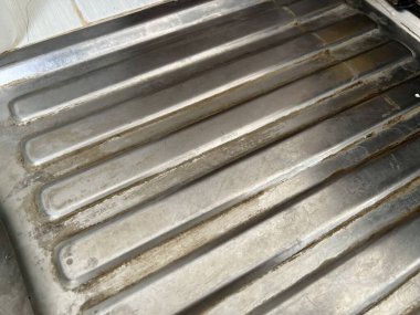 Paslanmaz çelik bir yüzeye yakın çekim, oyuklar ve incelikle...