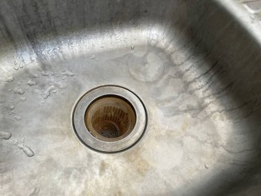 Su damlacıkları ve paslanmaz çelik lavabonun yakın görüntüsü. 