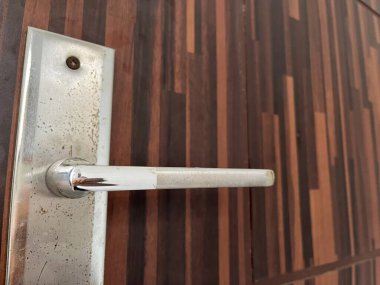 Ahşap bir yüzeyde metalik bir kapı kolunun yakın çekimi, showcasi