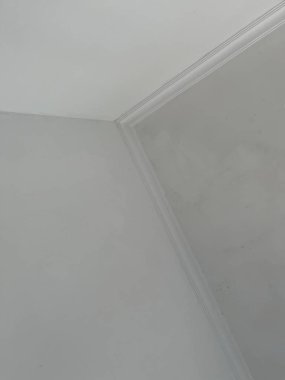 Odanın temiz bir köşesi, pürüzsüz duvarlar ve tavan nükteleri.