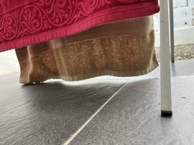 Sandalyenin bacağına sarılı dekoratif bir kumaşın yakın çekim görüntüsü.