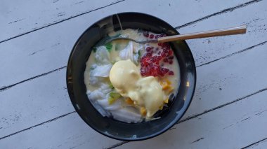 Bir kase renkli tatlı, içinde meyve, krema ve tatlı