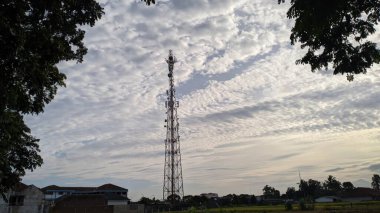 Uzun bir telekomünikasyon kulesi bulutlu bir kayak arkaplanına karşı