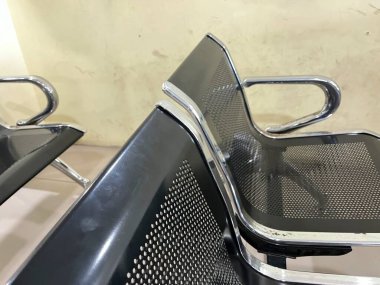 İki modern metal sandalye, parlak bir tasarımı ve ağ örgülü koltukları var..