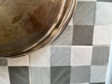 Metalik bir tencerenin yakın çekimi desenli bir yüzeye karşı..