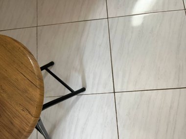 Döşeme üzerinde ahşap bir tabure, basit bir iç seti yakalıyor.