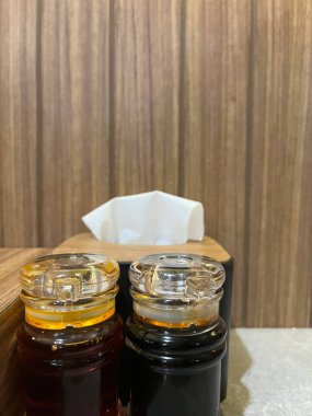 İki cam kavanoz baharat, bir kağıt mendil kutusunun yanında.