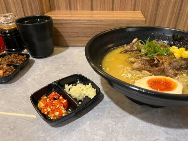 Bir kase erişte, yanında sos ve meze, Casua 'da servis edilir.