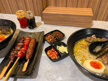 Erişteler, şişler ve çeşitli kondisyonlar içeren lezzetli bir yemek.