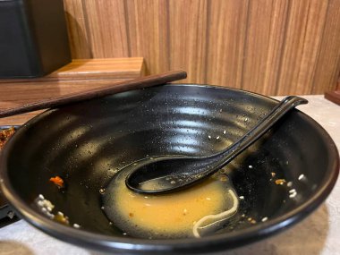 Neredeyse boş bir kase. Çorba artığı ve dinlenen bir kaşık.