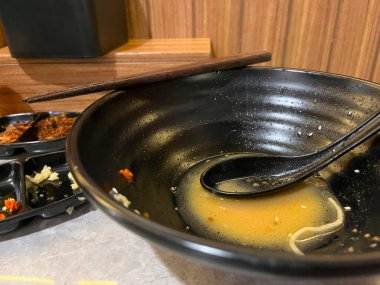 Çorba ve çubuk kalıntılarıyla dolu boş bir kase.