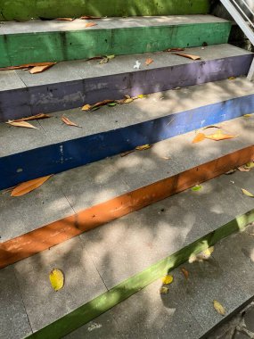 Renkli basamaklarla boyanmış beton merdivenler basamaklara saçılmış yapraklar, halk için bir doğa duygusu ve geçiş hissi uyandırıyor..