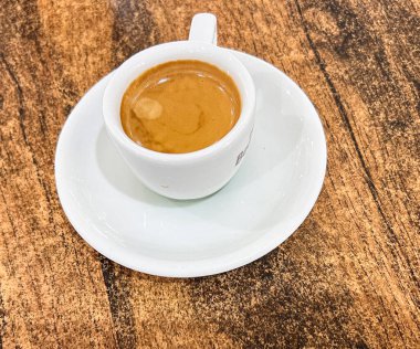 Tahta bir masada bir fincan aromatik sade kahve.