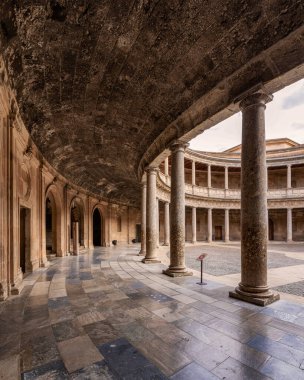 Sütunları ve duvarında saati olan büyük bir bina.