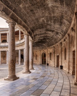 Dairesel yürüyüş yolu ve sütunları olan büyük bir bina.