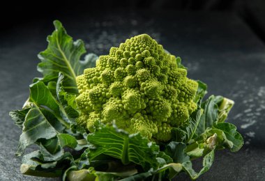 Romanesco brokoli kafası koyu bir taş yüzeyde, lahana, yakın plan, fibonacci dizisi, matematiği sevenler için.