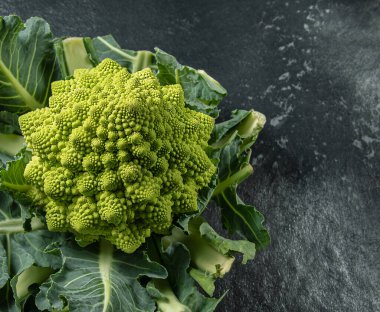 Romanesco brokoli kafası koyu bir taş yüzeyde, lahana, yakın plan, fibonacci dizisi, matematiği sevenler için.