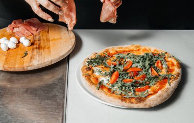 Pizzacıdaki fırından peynir, domates ve mozzarella ile pizza yerleştirme işlemi