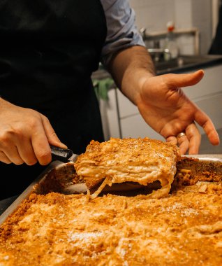 Fırından yeni çıkmış, sıcak lazanyalı şef, restoran mutfağı konsepti.
