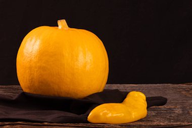 Ahşap bir masada sarı balkabağı ve uzun biber, yazı için yer.