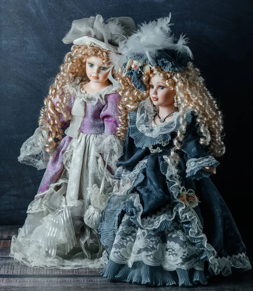 Mavi gözlü, gerçekçi klasik oyuncaklar. Mavi elbiseli ve sarı saçlı bebekler. Seçici odaklanma. Porselen bebekler.
